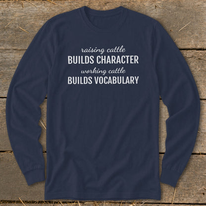 Navy long-sleeve shirt with white text: "raising cattle BUILDS CHARACTER, working cattle BUILDS VOCABULARY."