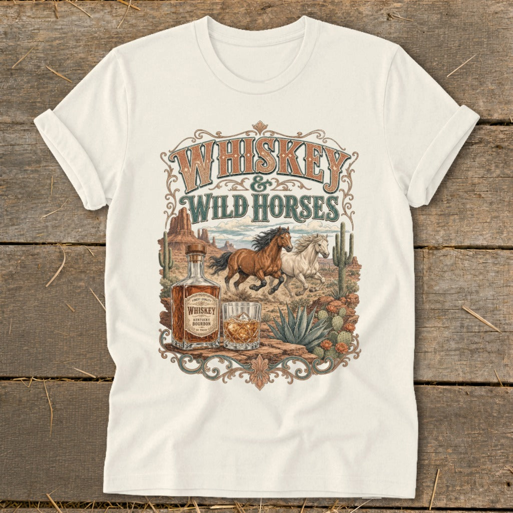 T-shirt graphic with whiskey and wild horses design, desert landscape, and bottle.