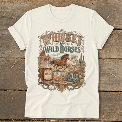 T-shirt graphic with whiskey and wild horses design, desert landscape, and bottle.