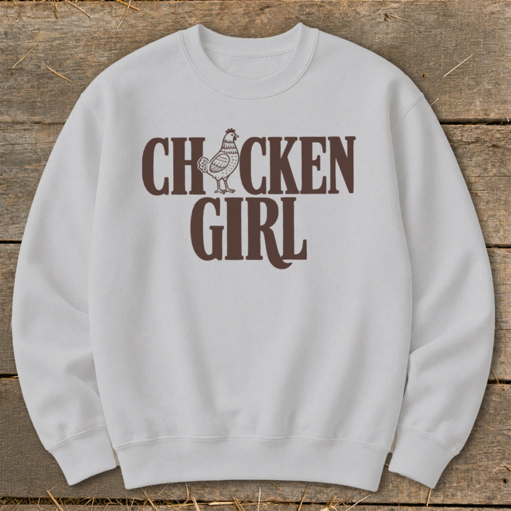 White sweatshirt with brown "CHICKEN GIRL" text and chicken graphic.