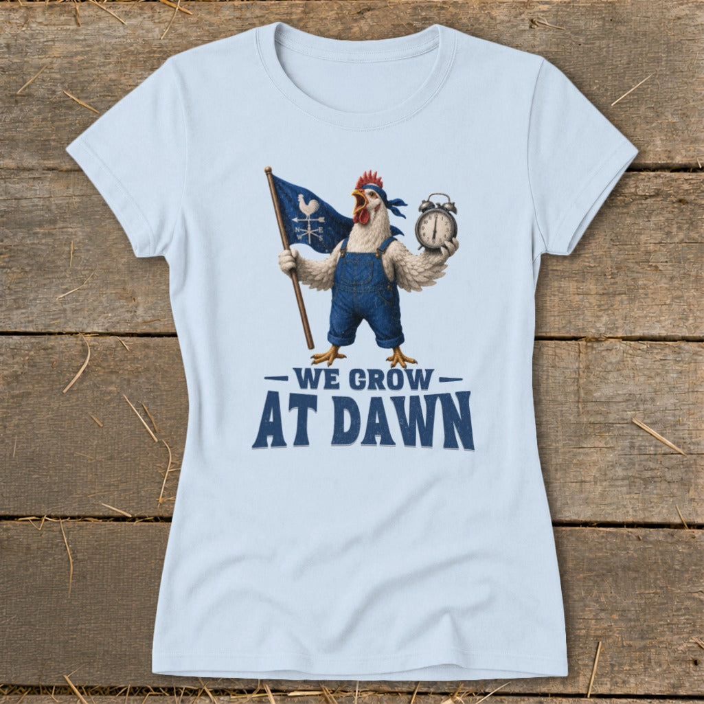 Light blue t-shirt with a chicken in overalls holding a flag and alarm clock, text reads "WE GROW AT DAWN".