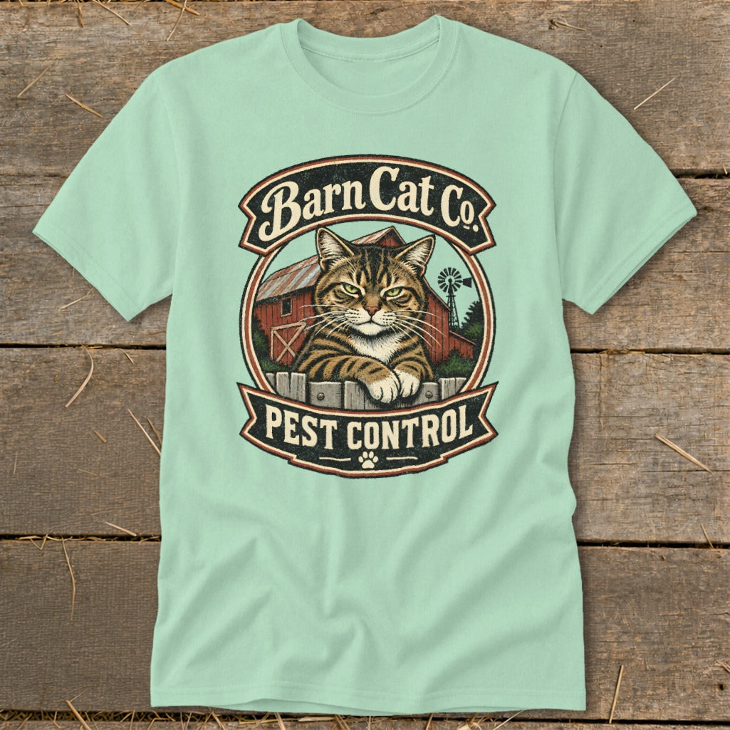 Light green t-shirt featuring a circular graphic with a tabby cat, red barn, and text reading Barn Cat Co. Pest Control.