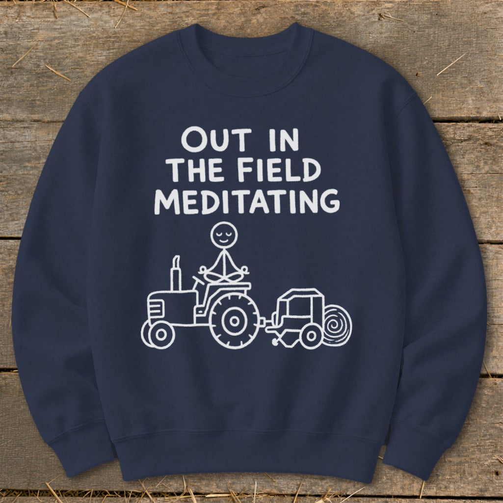 Navy sweatshirt with white text and cartoon of stick figure meditating on a tractor.