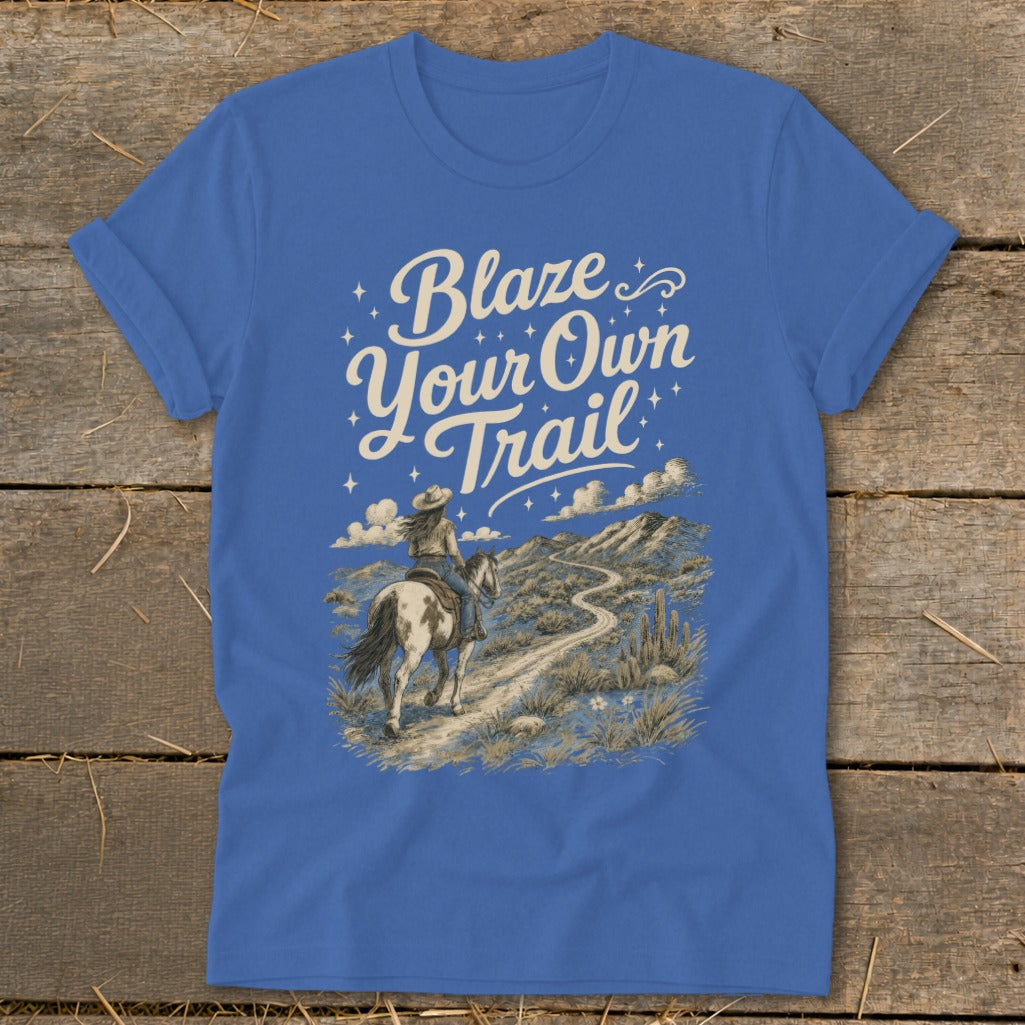 T-shirt with "Blaze Your Own Trail" text, showing a person riding a horse on a desert mountain path.