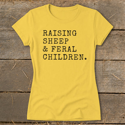 Yellow t-shirt with black text reading "RAISING SHEEP & FERAL CHILDREN."