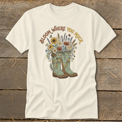 Cream t-shirt with boots overflowing with flowers and text "Bloom Where You Muck."