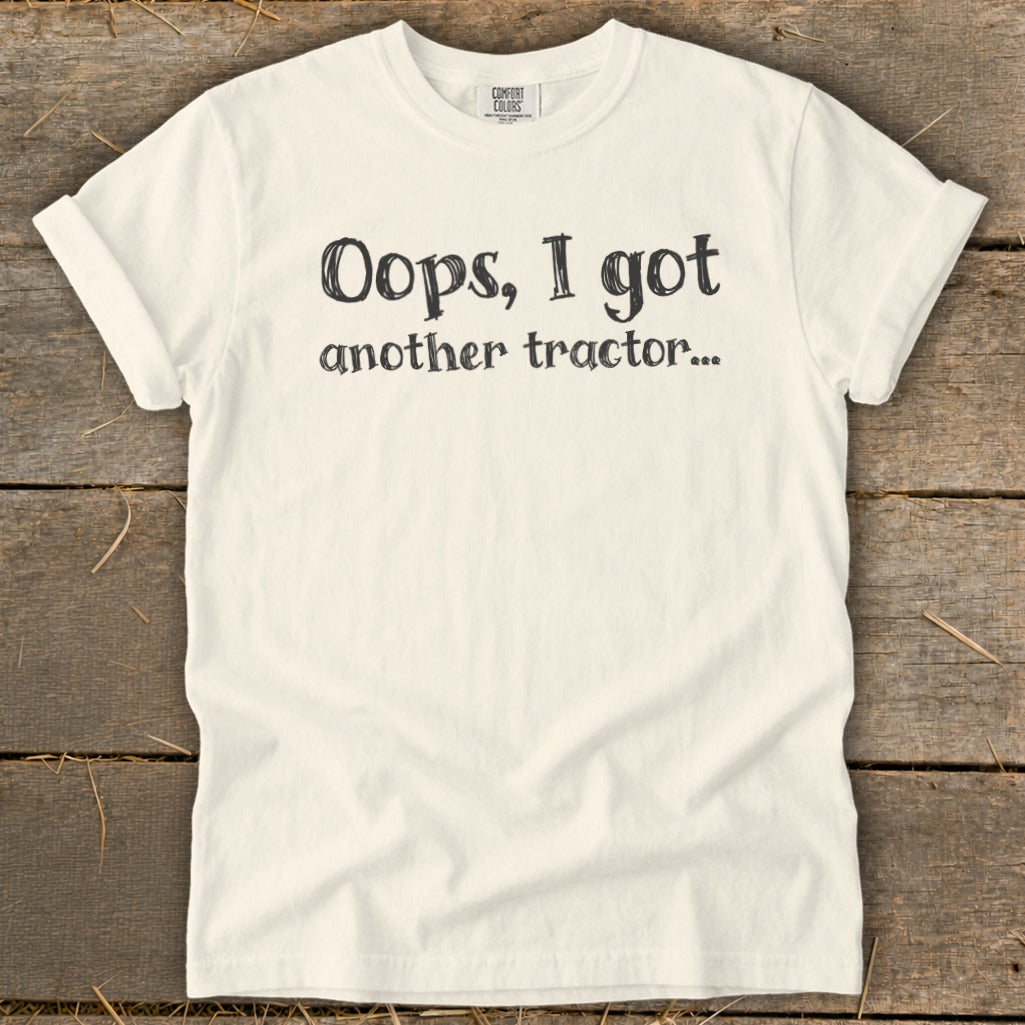 Cream t-shirt with black text that reads "Oops, I got another tractor..."