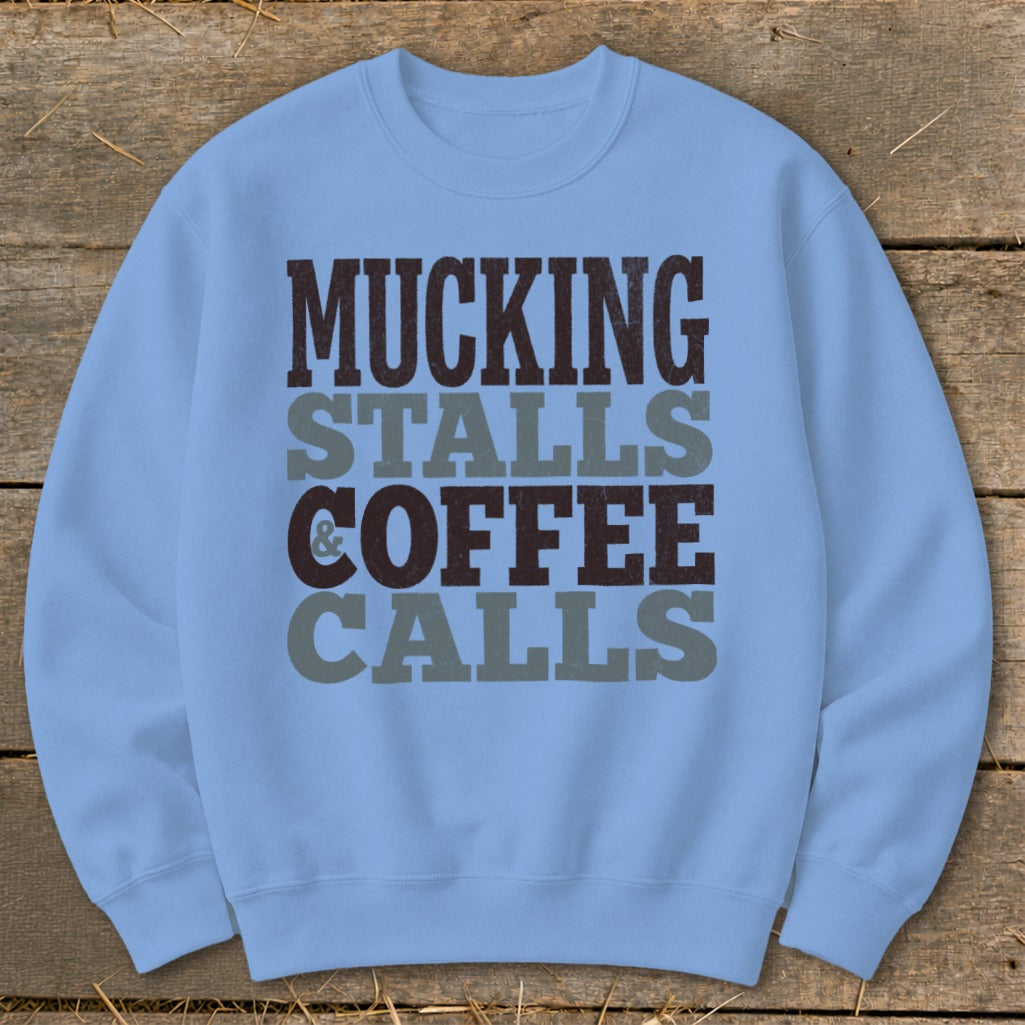 Light blue crewneck sweatshirt with text "Mucking Stalls & Coffee Calls".
