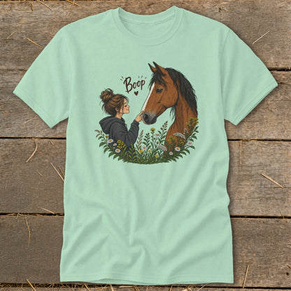 Girl touching nose of horse with text "Boop" above, surrounded by flowers.