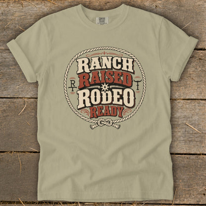 Olive green short-sleeve t-shirt with a vintage western graphic featuring the text Ranch Raised Rodeo Ready.