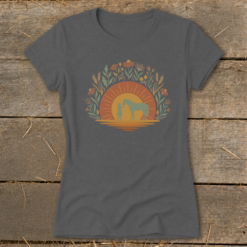 Girl with horse at sunset surrounded by wildflowers and wheat.