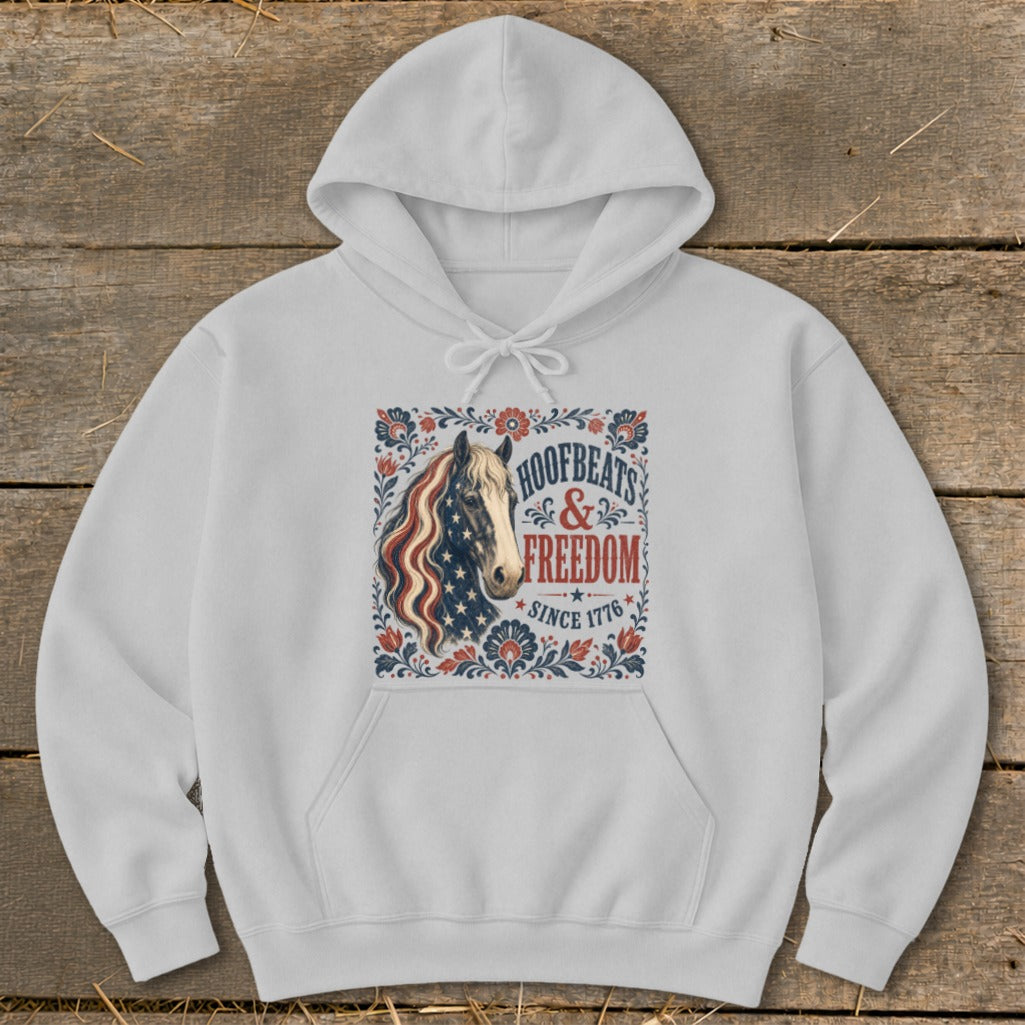 White hoodie with a patriotic horse graphic reading "Hoofbeats & Freedom Since 1776".