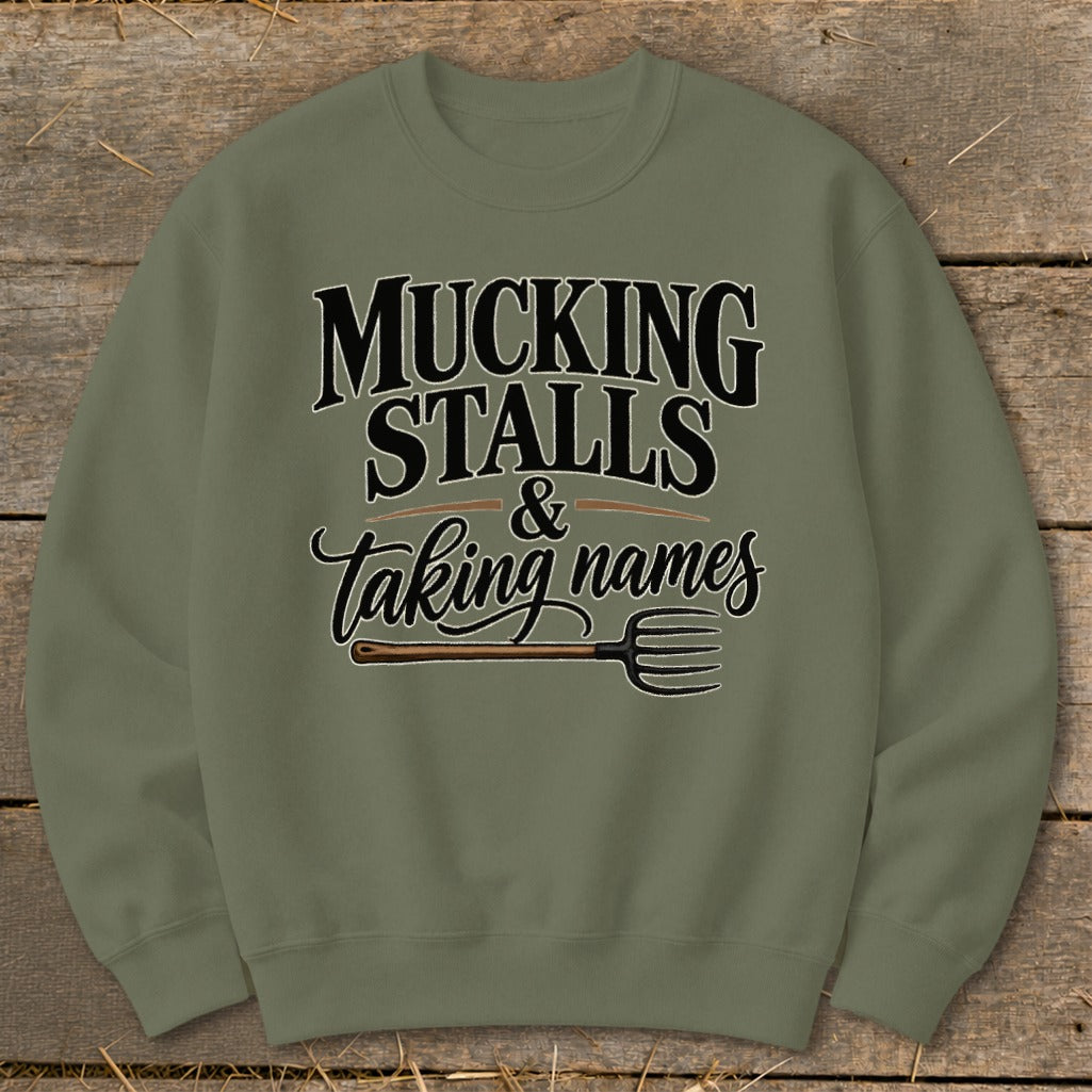 Olive green sweatshirt with "Mucking Stalls & Taking Names" text and pitchfork graphic.