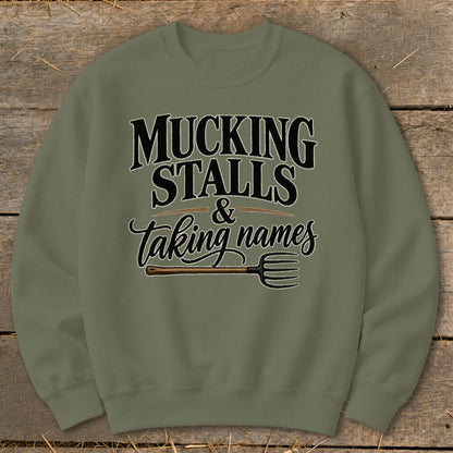 Olive green sweatshirt with "Mucking Stalls & Taking Names" text and pitchfork graphic.