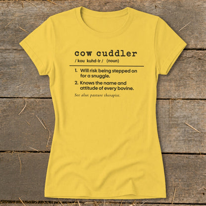 Yellow t-shirt with "cow cuddler" definition: loves cows, will risk getting stepped on.