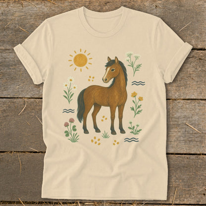 Light tan t-shirt with illustration of a brown horse surrounded by flowers and sun.