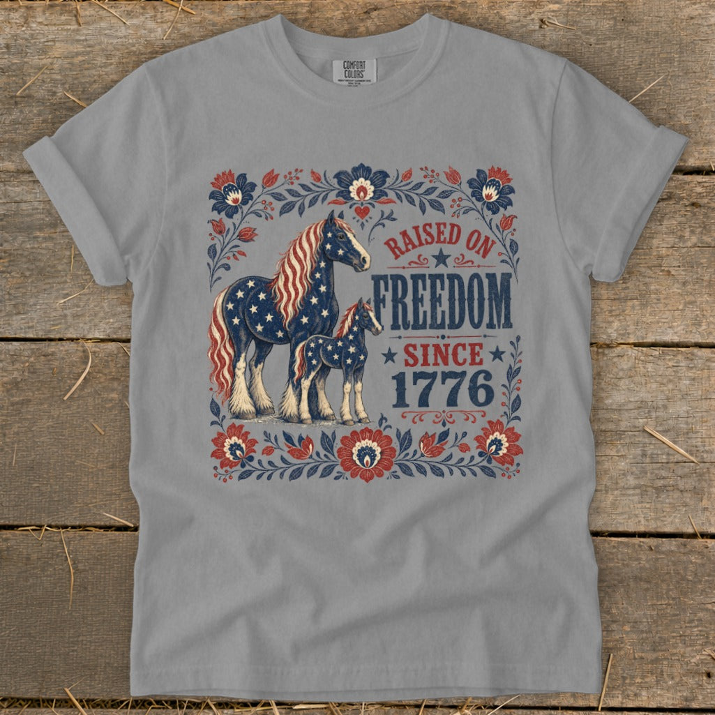T-shirt graphic with two horses patterned like the American flag and "Raised on Freedom Since 1776".
