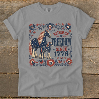 T-shirt graphic with two horses patterned like the American flag and "Raised on Freedom Since 1776".