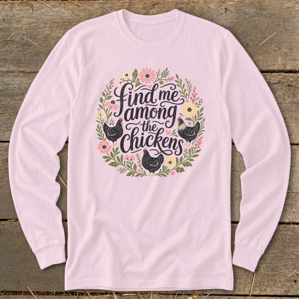 Pink long sleeve shirt with a floral wreath and "Find me among the chickens" text.