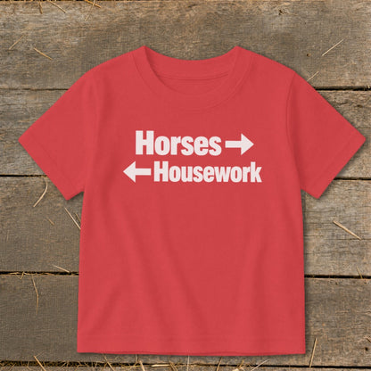 A red short-sleeved t-shirt with white text reading Horses with a right arrow and Housework with a left arrow.