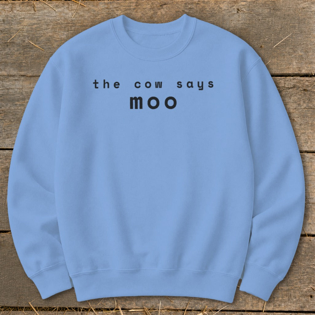 Light blue crewneck sweatshirt with black text "the cow says moo".