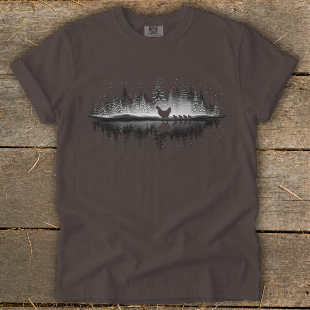 Dark gray t-shirt with hen and chicks graphic on wooded background.