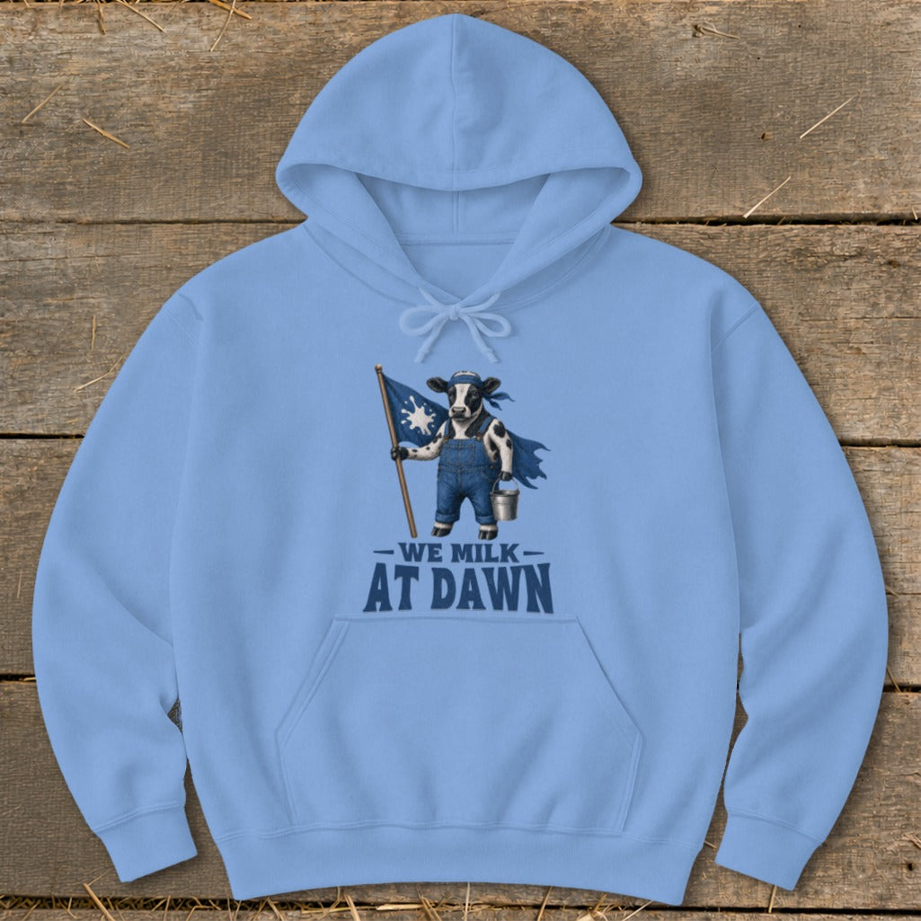Light blue hoodie with a cow graphic holding a flag and text "WE MILK AT DAWN".