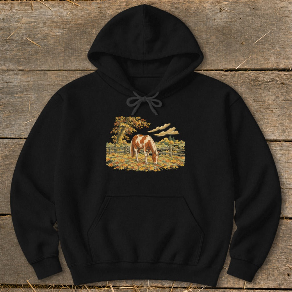 Black hoodie with a painting of a brown and white horse grazing in a field.