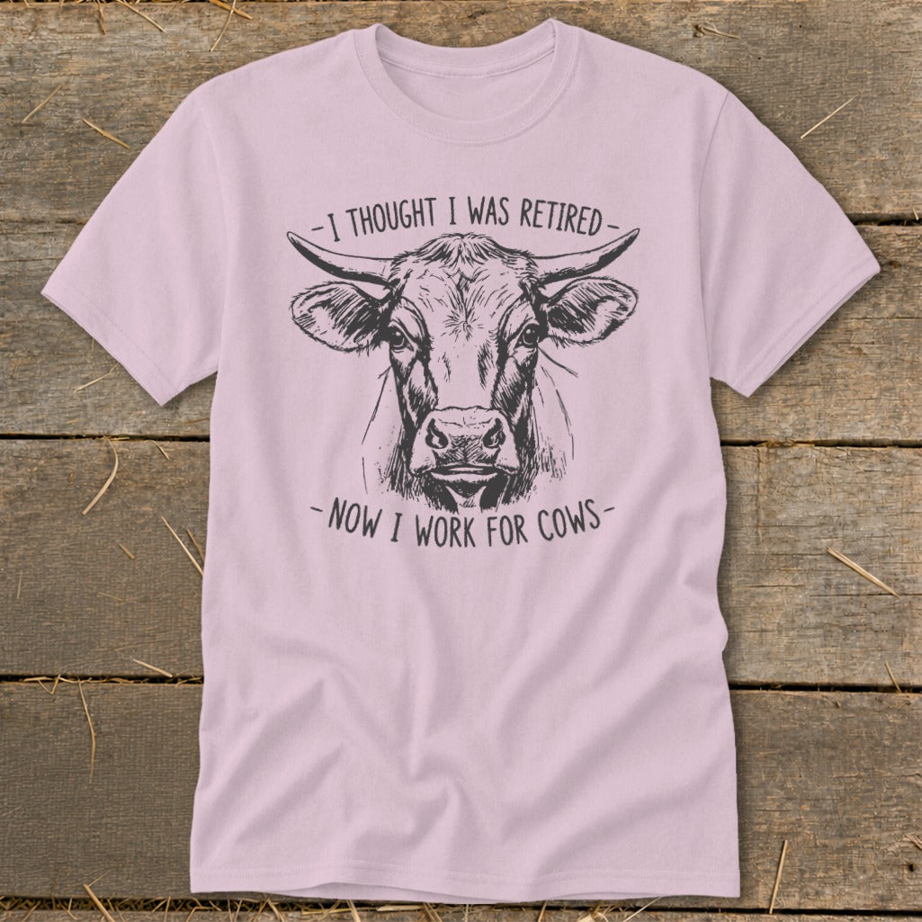 Pink t-shirt with a sketch of a cow's head and text "I thought I was retired - Now I work for cows".