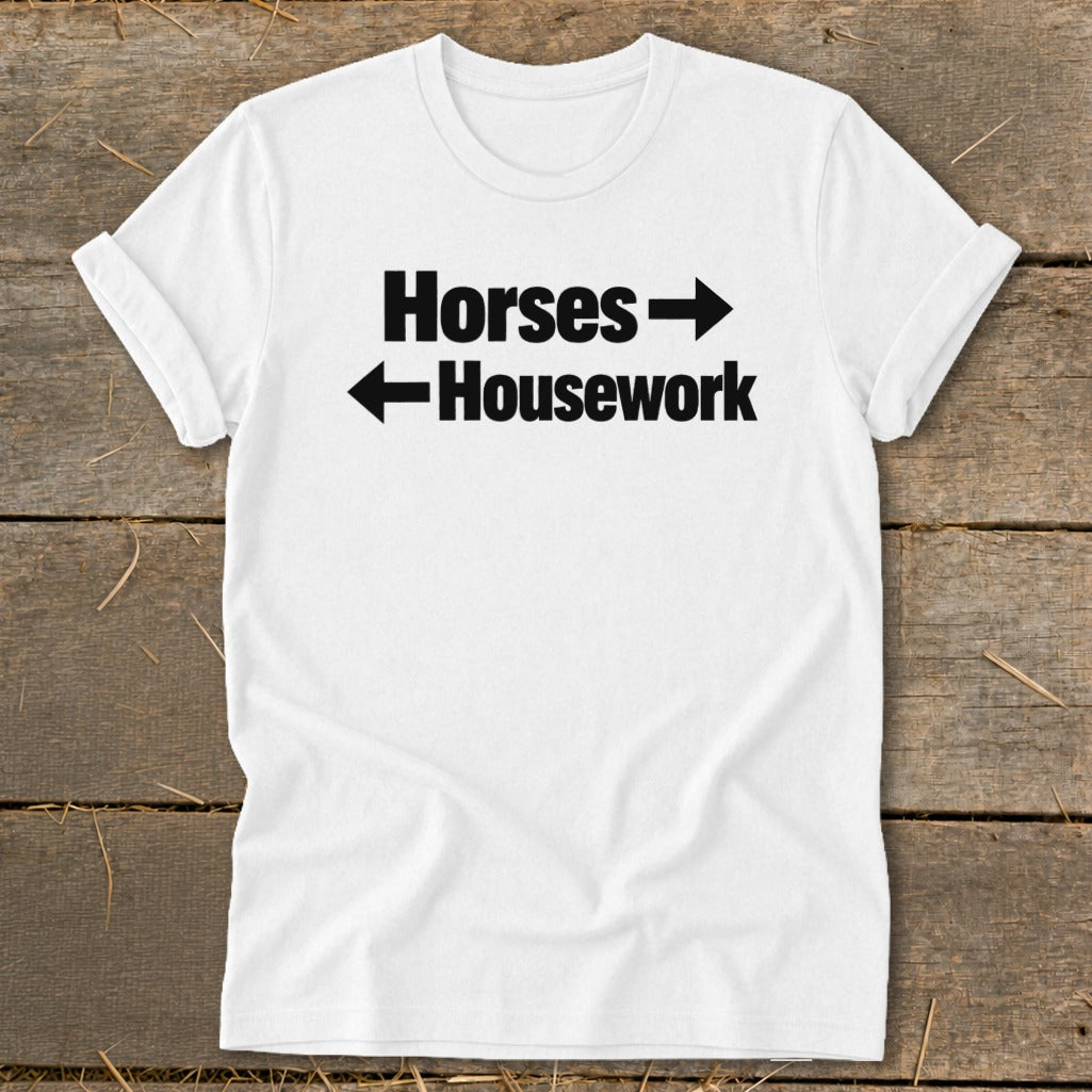 A white t-shirt with black text that reads "Horses" pointing right and "Housework" pointing left.