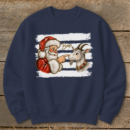 Santa playfully booping a goat's nose on a striped background.