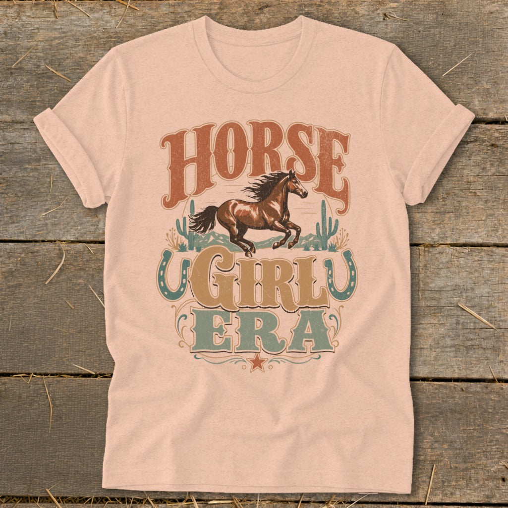 T-shirt graphic featuring a running horse, cacti, and the text "HORSE GIRLU ERA".