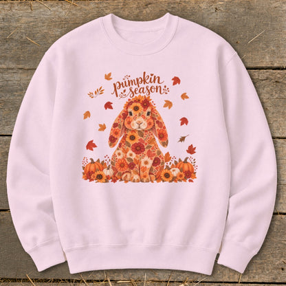 Pink sweatshirt with floral bunny and "pumpkin season" text surrounded by autumn leaves.