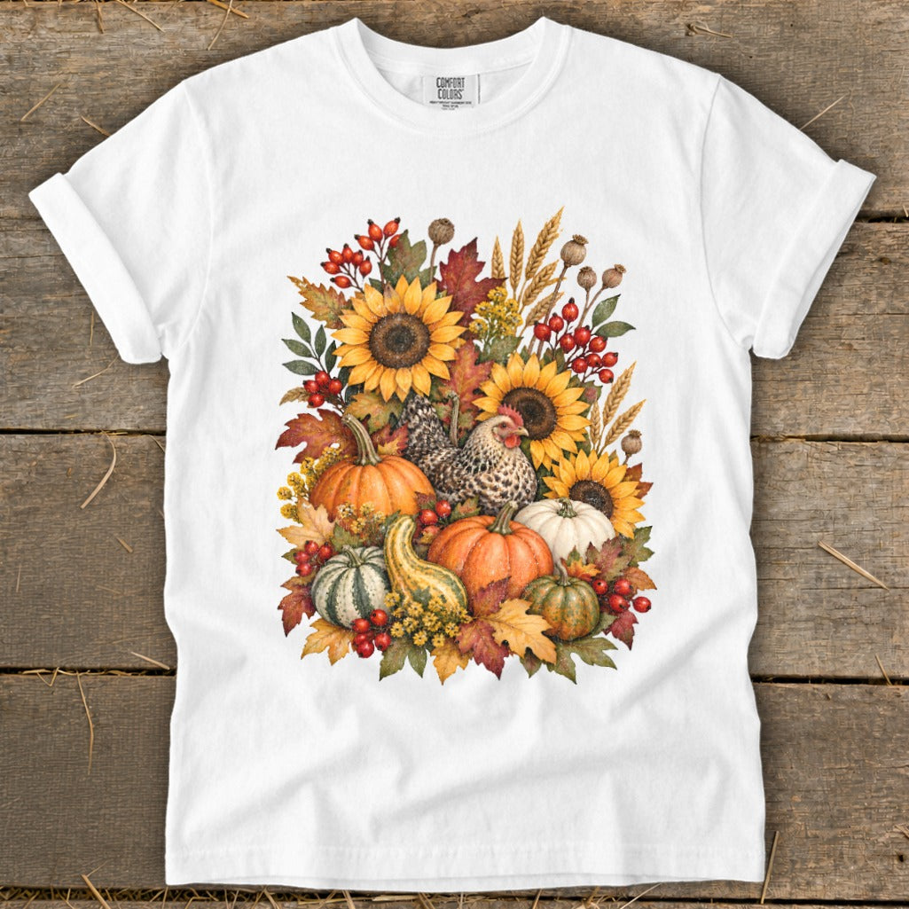 White t-shirt with a watercolor arrangement of sunflowers, pumpkins, gourds, and a hen.