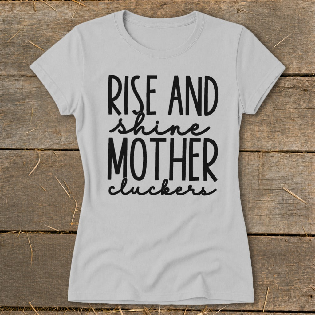 Light gray t-shirt with black text: "Rise and shine mother cluckers."