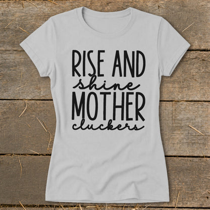Light gray t-shirt with black text: "Rise and shine mother cluckers."