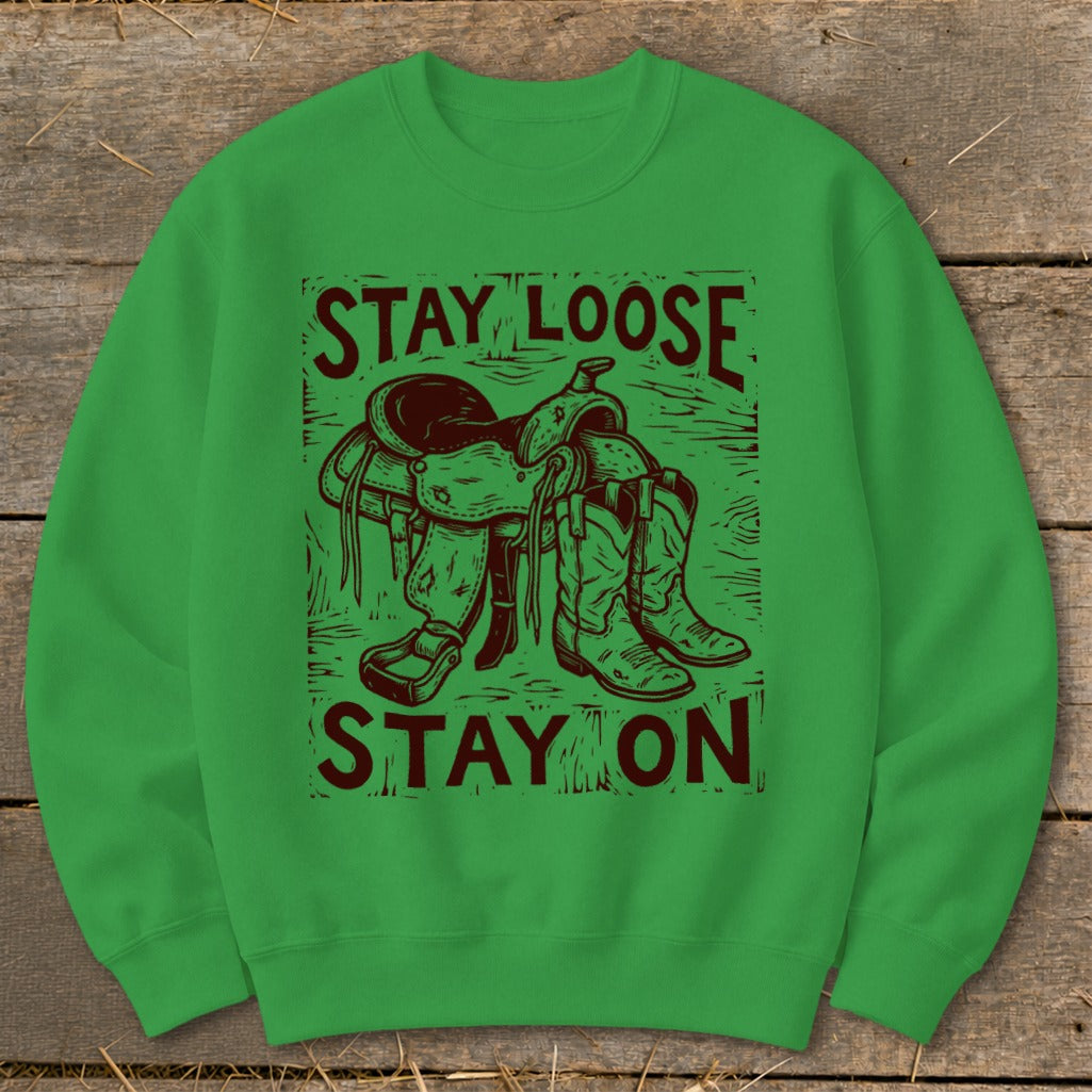 Green sweatshirt with a Western saddle and boots graphic and text: Stay Loose Stay On.