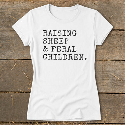 White t-shirt with black typewriter text: "RAISING SHEEP & FERAL CHILDREN."
