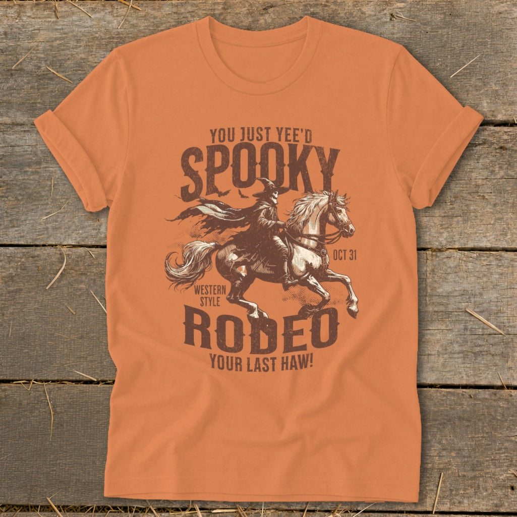 Orange t-shirt with "Spooky Rodeo Your Last Haw!" graphic and witch on horse.
