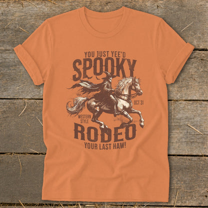 Orange t-shirt with "Spooky Rodeo Your Last Haw!" graphic and witch on horse.