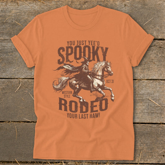 Orange t-shirt with "Spooky Rodeo Your Last Haw!" graphic and witch on horse.