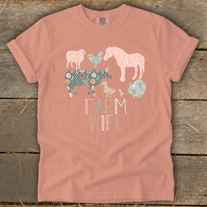 Peach Comfort Colors t-shirt with "FARM WIFE" text and farm animals in floral patterns.
