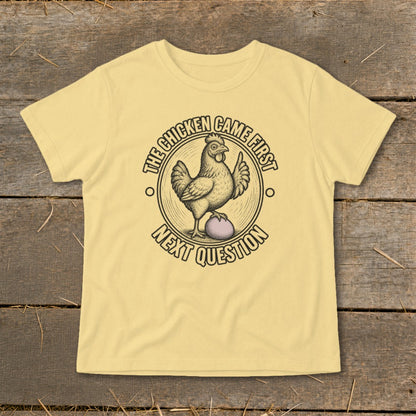 Yellow t-shirt with a chicken and egg graphic and text "The chicken came first, next question".