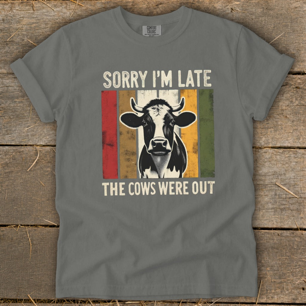 Grey t-shirt with a cow graphic and text "SORRY I'M LATE THE COWS WERE OUT".