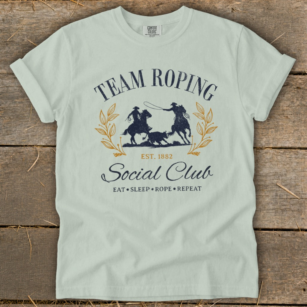 Light blue t-shirt with "Team Roping Social Club" and rodeo graphic.