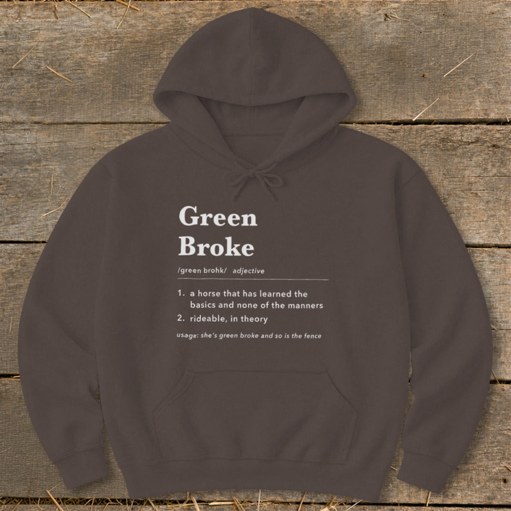 Dark brown hoodie featuring white dictionary-style text defining the phrase Green Broke against a wooden background.