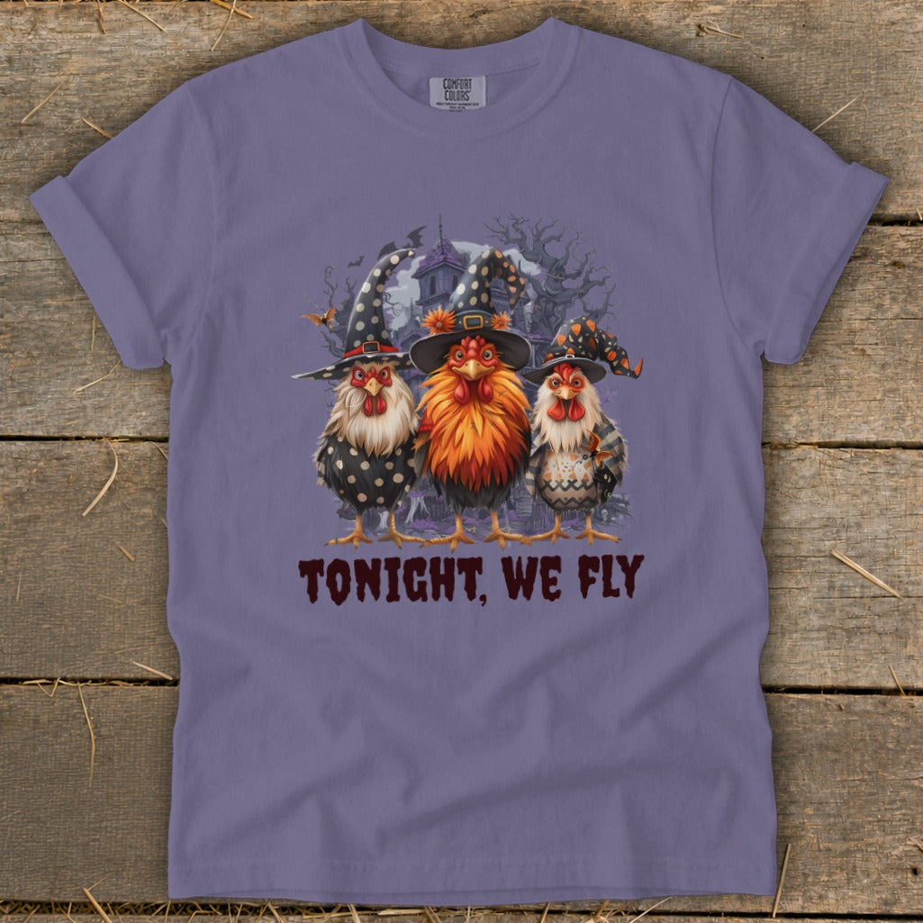 Three chickens in witch hats stand before a spooky house with text that reads "TONIGHT, WE FLY."
