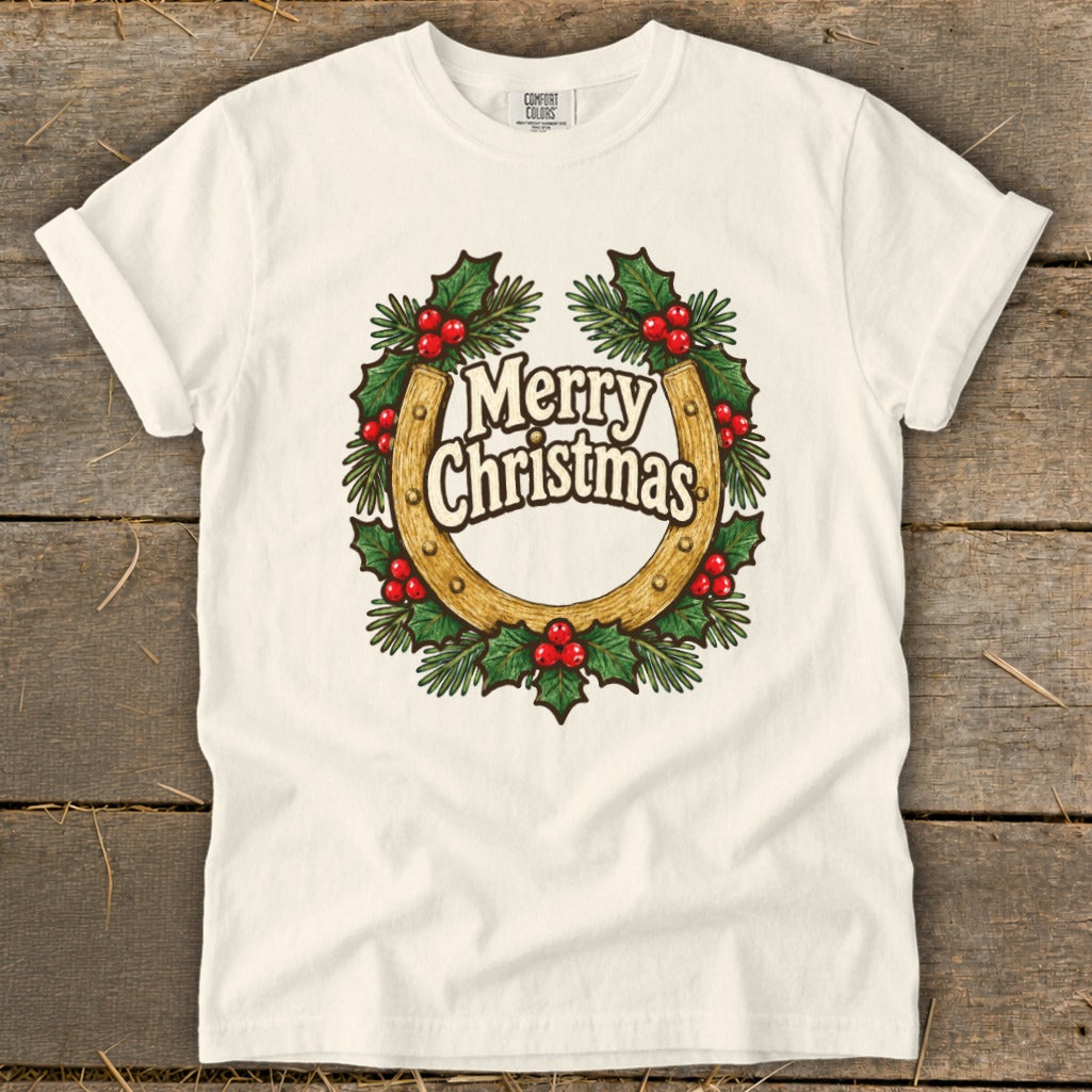 White t-shirt with a horseshoe wreath graphic saying "Merry Christmas".