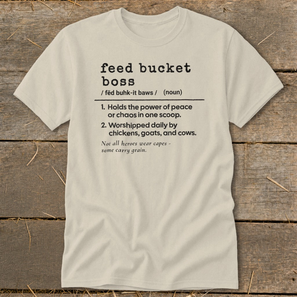 Light tan t-shirt with "feed bucket boss" definition including chickens, goats, and cows.