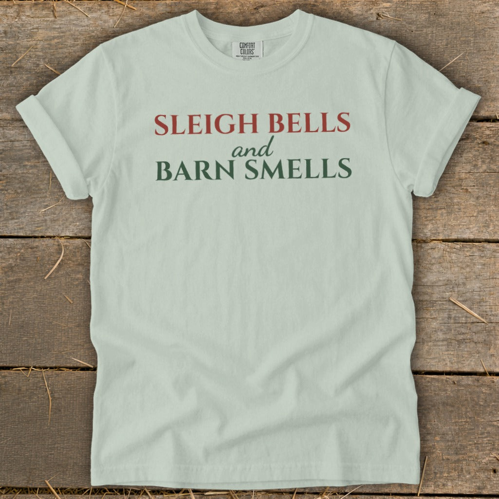 Light green t-shirt with red and green text reading "Sleigh Bells and Barn Smells".